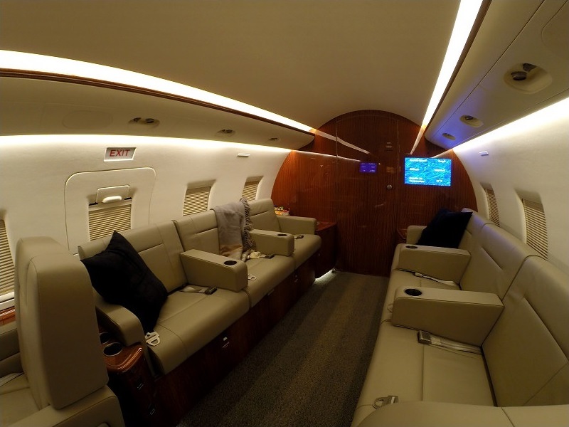 Private jet cabin with sofa and reclining seats for accessible travel from Boca Raton, Florida