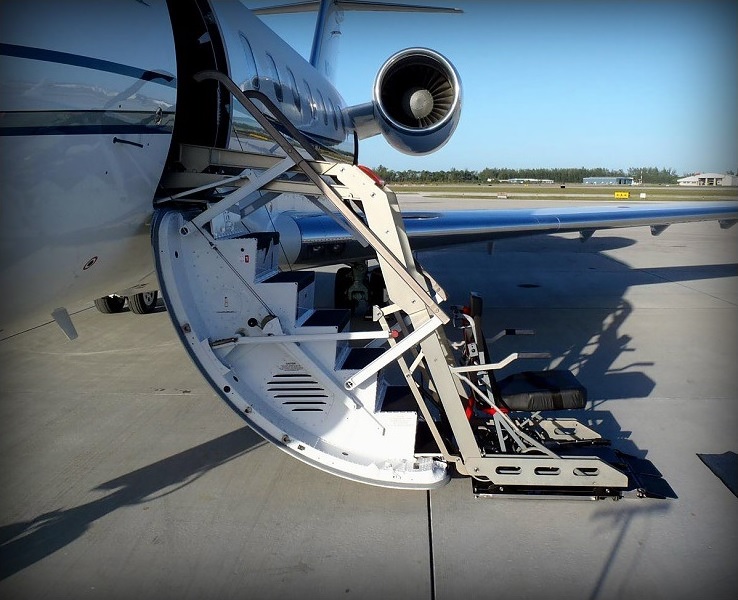 Wheelchair lift positioned alongside a private jet for boarding in Boca Raton, Florida